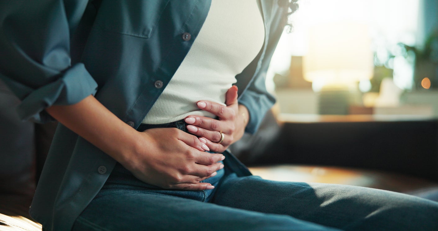 Person holds stomach in pain